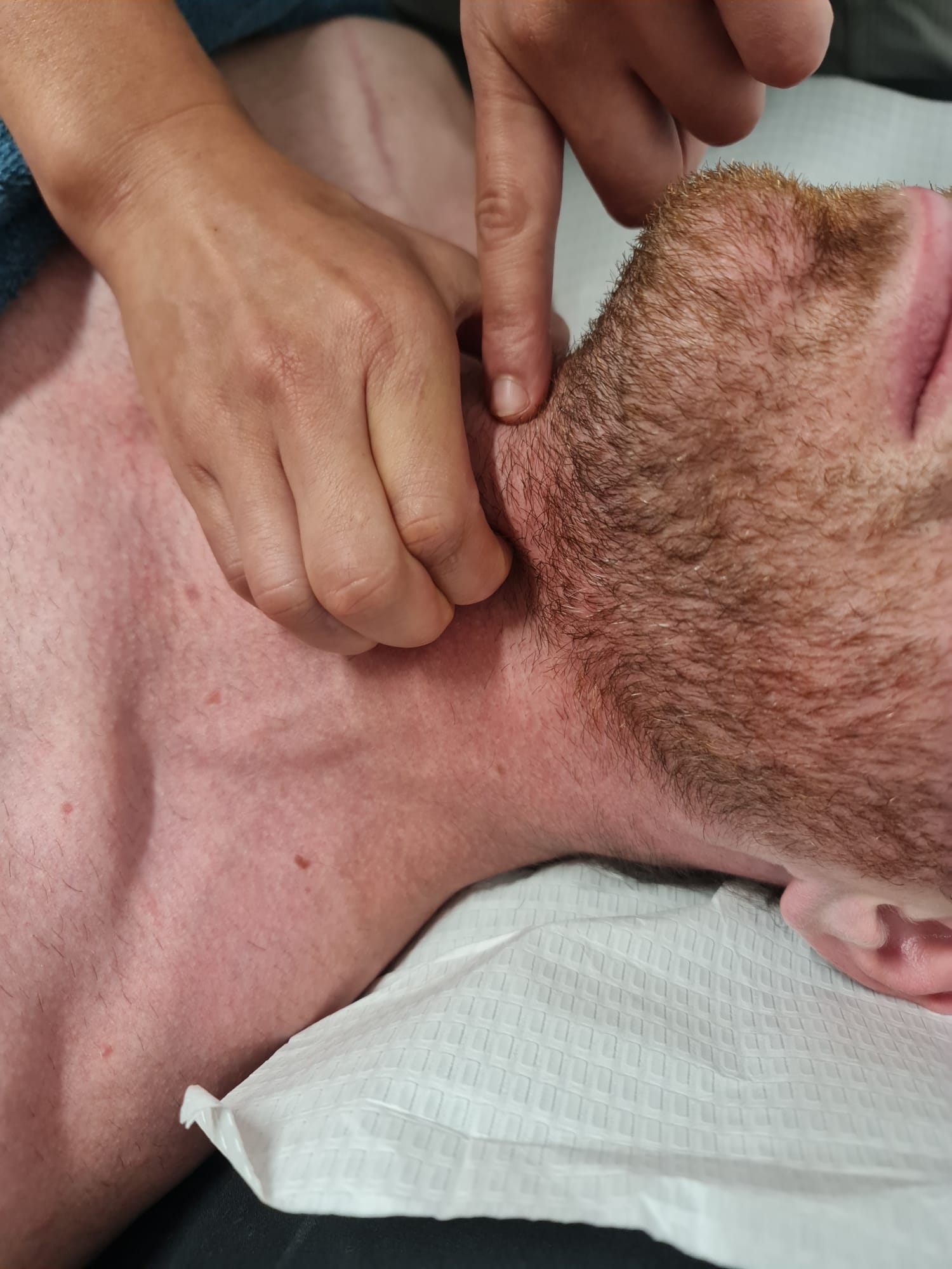 Close-up of hands-on treatment to jaw and throat area during Vocal Physiotherapy session