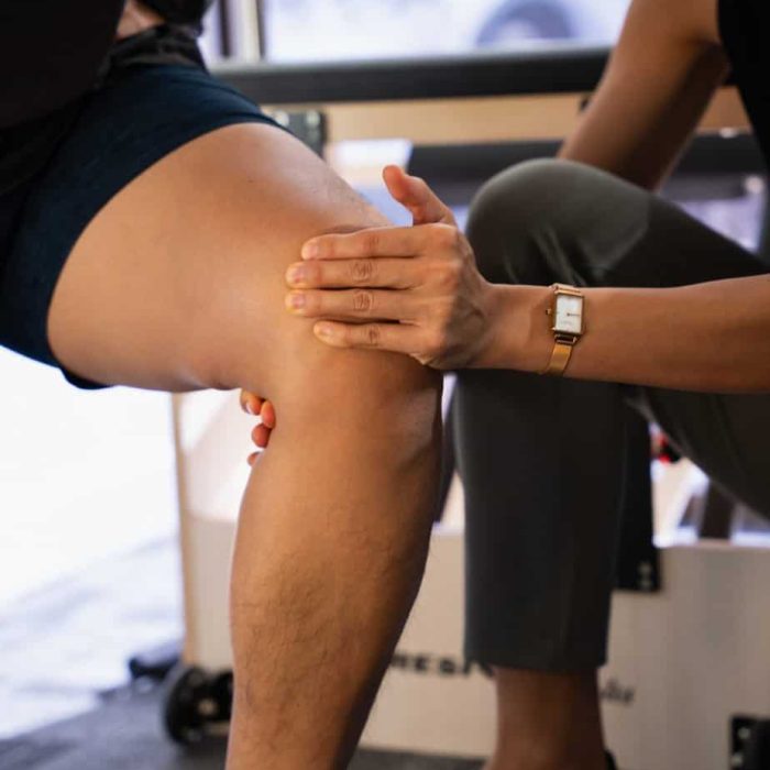 Physiotherapist treating knee pain in a patient